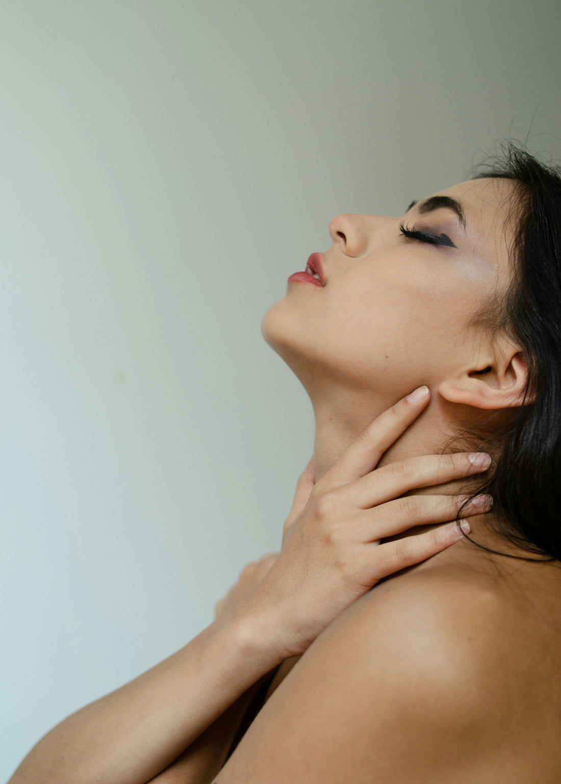 Femme appliquant sa routine soin visage à domicile avec un appareil LED et EMS en 10 minutes par jour